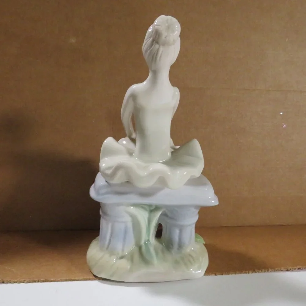 Ceramic Ballerina Figure sitting on bench with Roses